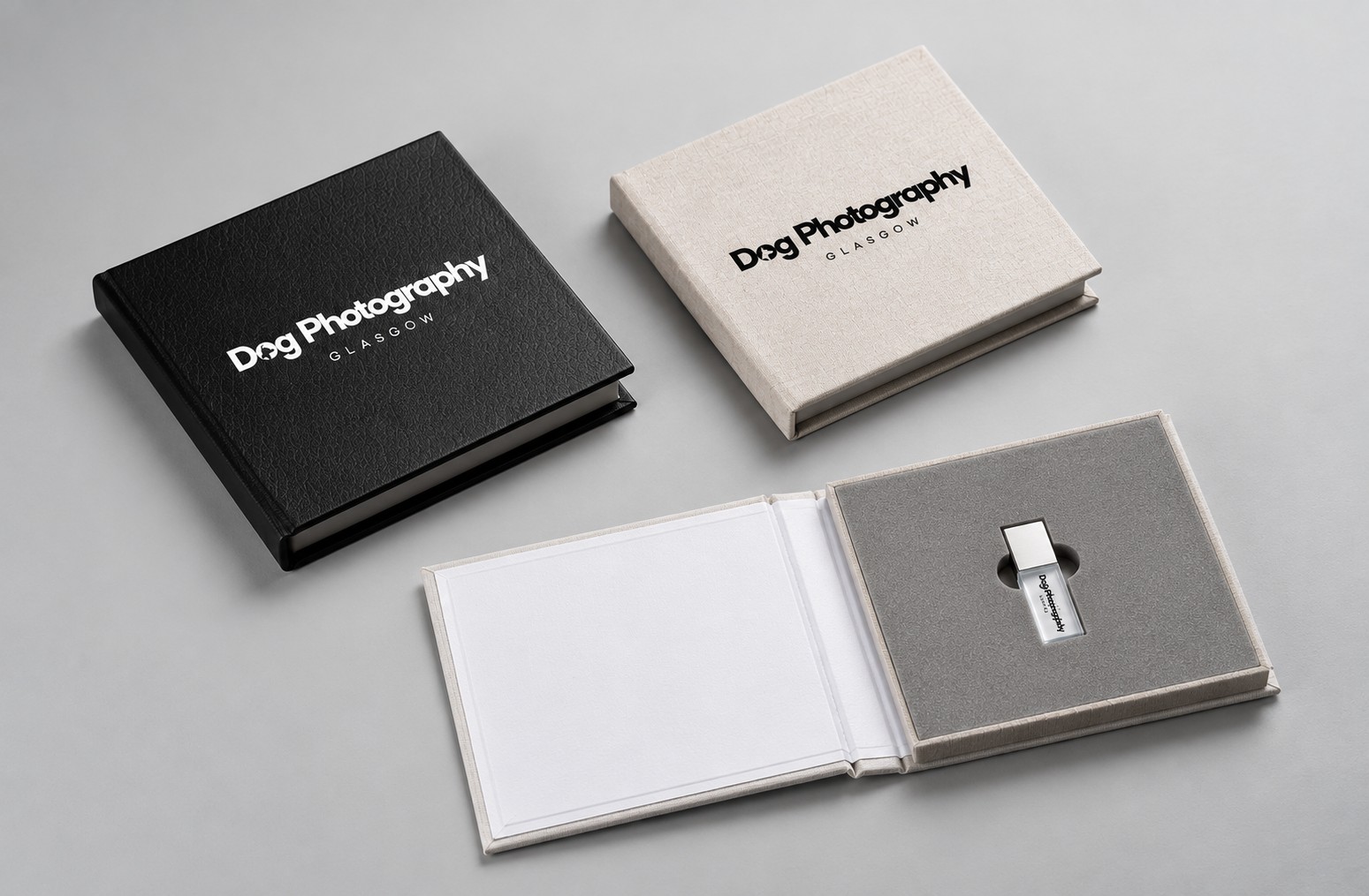 Personalised USB presentation cases in black and linen finishes, one open to reveal a branded USB drive
